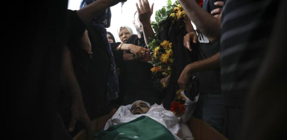 Palestinos se congregan en torno al cadáver de Mohammad Kiwan, de 17 años y que, según su familia, murió en enfrentamientos con la policía israelí en la localidad árabe de Umm al-Fahm, el 20 de mayo de 2021. (AP Foto/Mahmoud Illean)