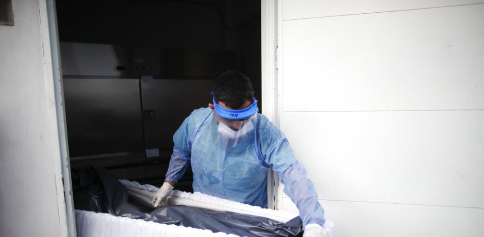 Un trabajador sanitario traslada un ataúd con los restos de un paciente fallecido por COVID-19 en el Hospital Llavallol Dr. Norberto Raúl Piacentini en Lomas de Zamora, Argentina, el viernes 23 de abril de 2021.

Foto: AP/Natacha Pisarenko