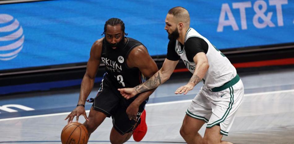 El escolta de los Brooklyn Nets, James Harden, impulsa hacia la canasta y supera al escolta de los Boston Celtics, Evan Fournier.