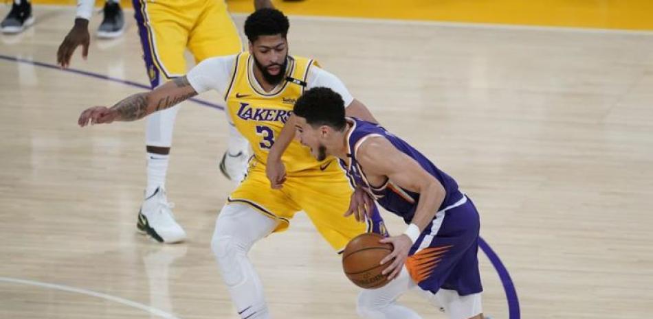 Anthony Davis, de los Lakers, defiende ante su rival de los Suns de Phoenix Devin Booker en el primer cuarto del Juego 6 de la primera ronda de los playoffs de la NBA.