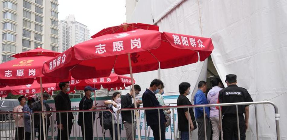 Residentes hacen fila en el exterior de un centro de vacunación contra el COVID-19, en Beijing, el 2 de junio de 2021. (AP Foto/Ng Han Guan)