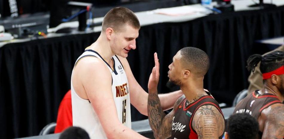 Nikola Jokic, a la izquierda, de Denver y Damian Lillard, de Portland, comparten un saludo al final del sexto partido de la serie de primera ronda de los playoffs de la NBA.