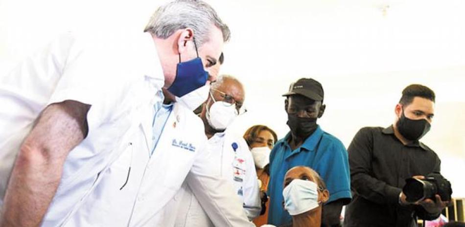 El presidente Luis Abinader conversa con una señora durante el proceso de vacunación en el sector Los Guandules, del Distrito Nacional. J. A. MALDONADO.