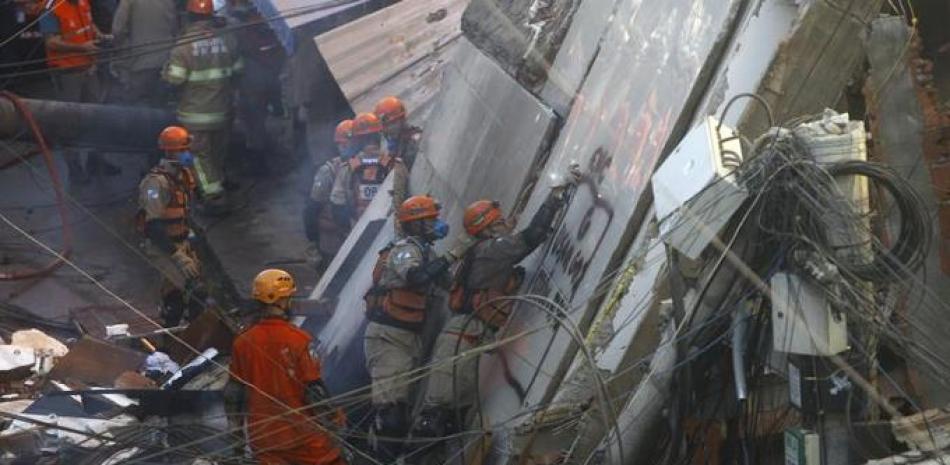 Bomberos buscan sobrevivientes después de retirar algunos escombros de un edificio de cuatro pisos que se vino abajo durante la noche en la favela de Río das Pedras, la madrugada del jueves 3 de junio de 2021, en Río de Janeiro. (AP Foto/Bruna Prado)