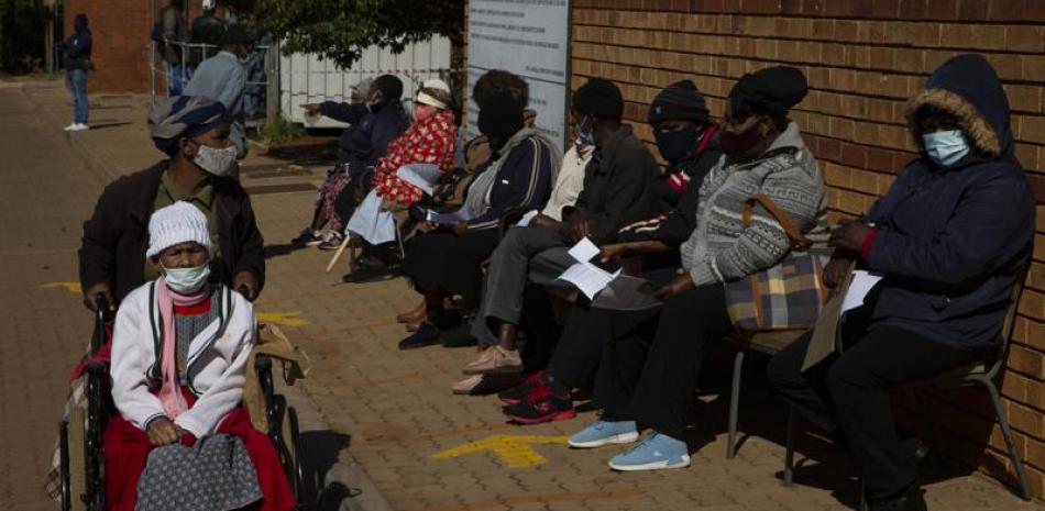Una mujer de la tercera edad abandona el lugar en que otras esperan recibir la vacuna de Pfizer contra el COVID-19 en una clínica en Orange Farm, cerca de Johannesburgo, Sudáfrica, el jueves 3 de junio de 2021. (AP Foto/Denis Farrell)
