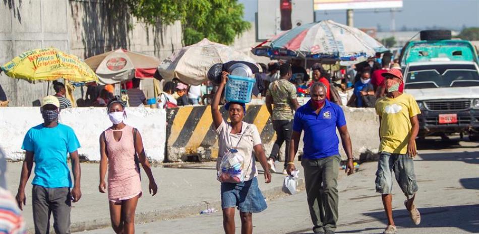 Varias personas con mascarilla caminan por una calle en Puerto Príncipe (Haití). EFE/Jean Marc Herve Abelard/Archivo