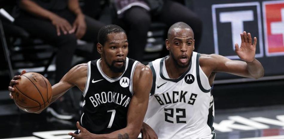 El alero de los Nets de Brooklyn, Kevin Durant, pasa frente al alero de los Bucks de Milwaukee, Khris Middleton, durante la segunda parte del juego de la NBA, el sábado 5 de junio de 2021, en Nueva York.