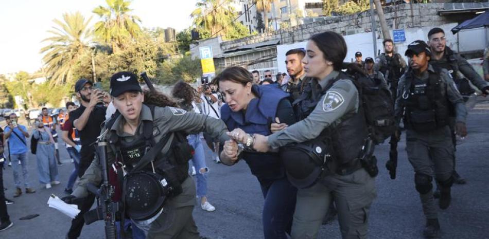 Agentes de las fuerzas de seguridad israelíes detienen a la periodista de Al Jazeera Givara Budeiri, durante una protesta en el barrio de Sheikh Jarrah, Jerusalén Oriental, el sábado 5 de junio de 2021. (AP Foto/Oren Ziv)