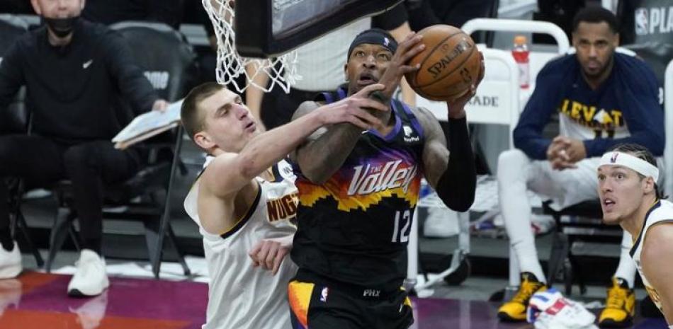 Torey Craig, de Phoenix, realiza una gestión ofensiva ante la defensa de Nikola Jokic, de Denver, en el primer partido de la segunda ronda de los playoffs de la NBA.