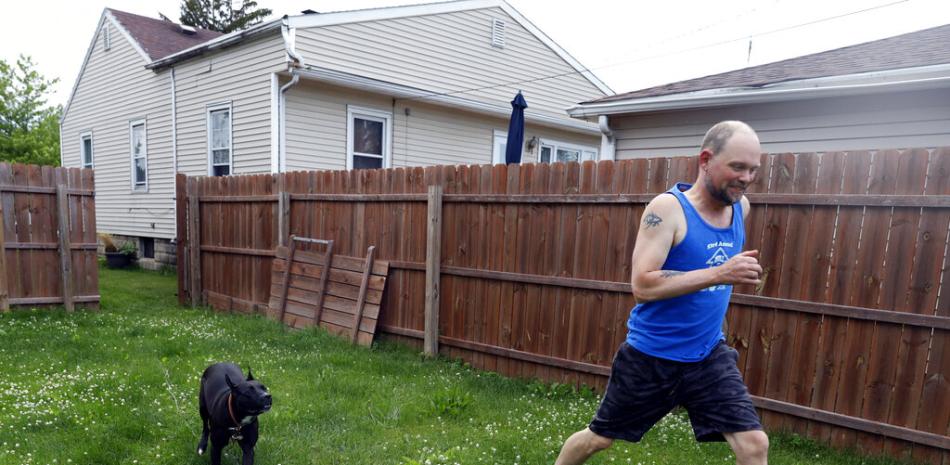 Christian Hainds juega con su perra Reyna en el patio de su casa en Hammond, Indiana, el 7 de junio de 2021.

Foto: AP/Shafkat Anowar