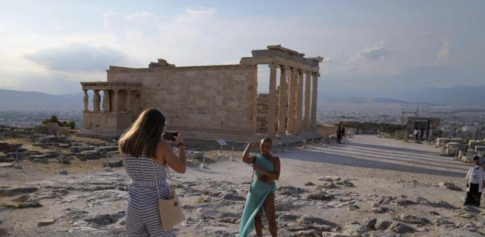 En esta imagen de archivo, tomada el 8 de junio de 2021, una turista toma fotos delante del Partenón durante una visita para reporteros extranjeros organizada por el Ministerio de Cultura griego a la Acrópolis, en Atenas. (AP Foto/Thanassis Stavrakis, arhivo)