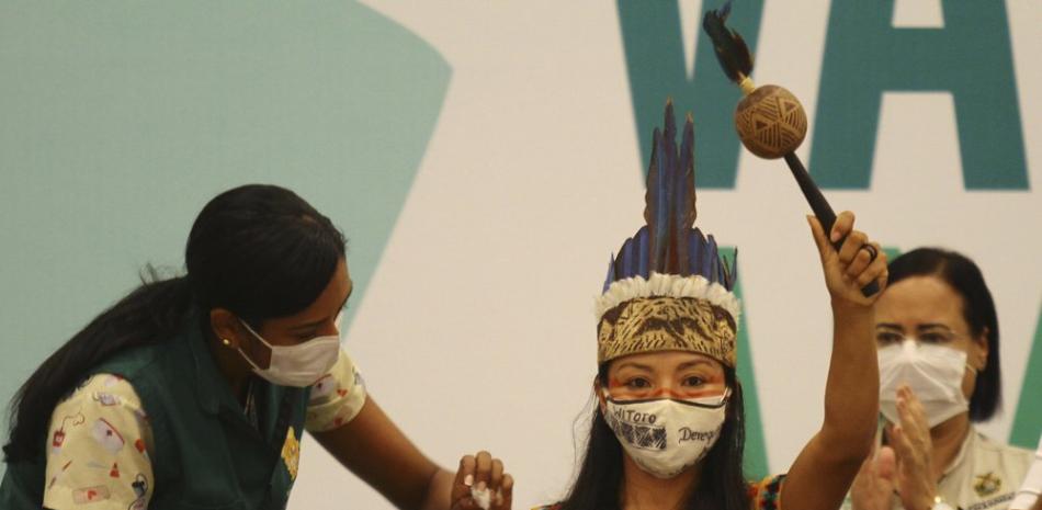 Luciendo ropa tradicional de su tribu, Vanda Ortega recibe la vacuna contra el COVID-19 en Manaus, Brasil, el 18 de enero del 2021. Ortega es la primera indígena witoto que se hizo vacunar contra elvirus en una región donde mucha gente no confía en la vacuna. (AP Photo/Edmar Barros, File)