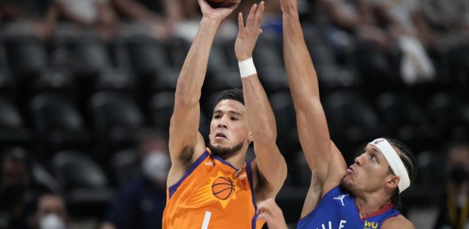 Devin Booker, de los Suns de Phoenix, lanza a canasta ante la defensa de su rival de los Nuggets de Denver Aaron Gordon en la primera mitad del tercer juego de la segunda ronda de los playoffs de la NBA. AP Foto/David Zalubowski)