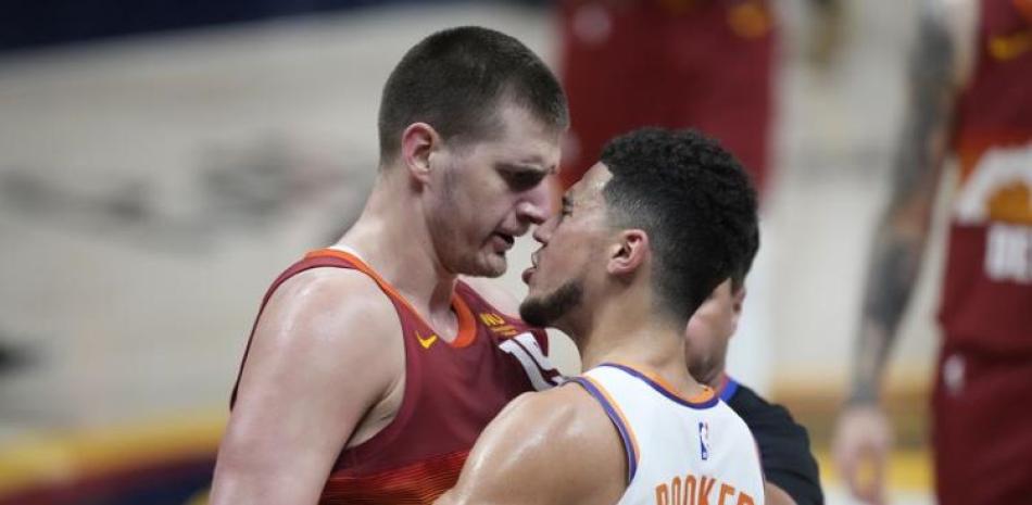 Nikola Jokic, de los Nuggets, a la izquierda discute con Devin Booker, de los Suns, durante el cuarto partido de la serie semifinal del Oeste en los playoffs de la NBA.