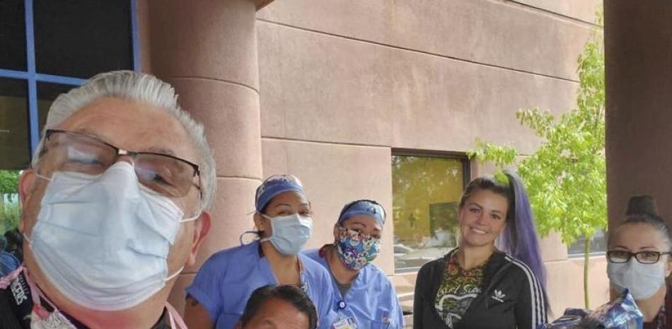 Fotografía sin fecha proporcinada por Girl Scouts of New Mexico Trails de Henrique Valdovinos, izquierda, y otros trabajadores de salud en el Hospital de la Mujer Lovelace en Albuquerque, Nuevo México, recibiendo una donación de galletas como parte del programa Hometown Heroes de las niñas exploradoras. (Girl Scouts of New Mexico Trails vía AP)