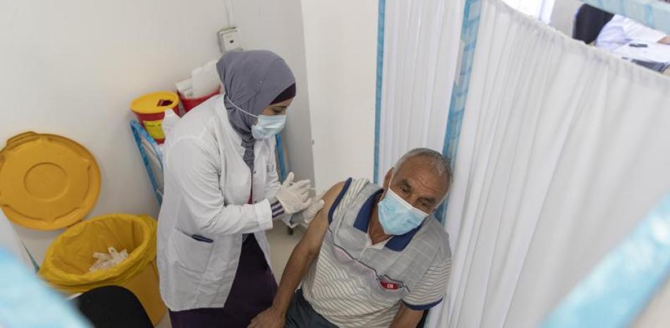 Una trabajadora sanitaria administra una dosis de la vacuna contra el COVID-19 desarrollada por AstraZeneca y la Universidad de Oxford a un palestino durante una campaña de vacunación, en Ramala, Cisjordania, el 6 de junio de 2021. (AP Foto/Nasser Nasser)