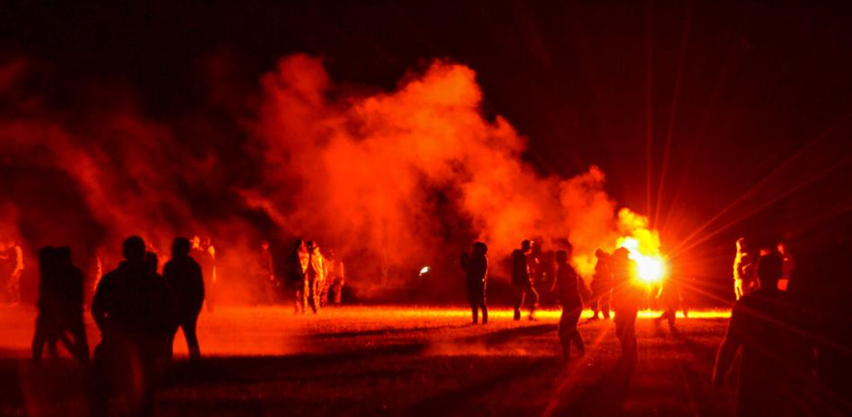 Jóvenes en un campo durante enfrentamientos con la policía mientras los agentes buscaban disolver una fiesta rave no autorizada cerca de Redon, Francia, la noche del viernes 18 de junio de 2021.

Foto: AP