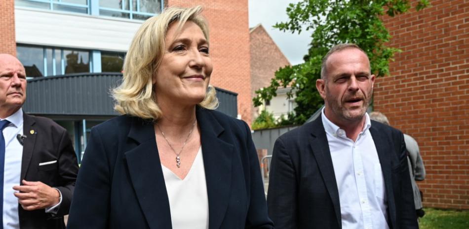 El líder del partido de extrema derecha francesa Rassemblement National (RN) y miembro del parlamento Marine Le Pen (L) y el alcalde de Henin-Beaumont Steeve Briois (R) abandonan un colegio electoral en Henin-Beaumont, en el norte de Francia, para la primera ronda de las elecciones regionales francesas del 20 de junio de 2021.
DENIS CHARLET / AFP
