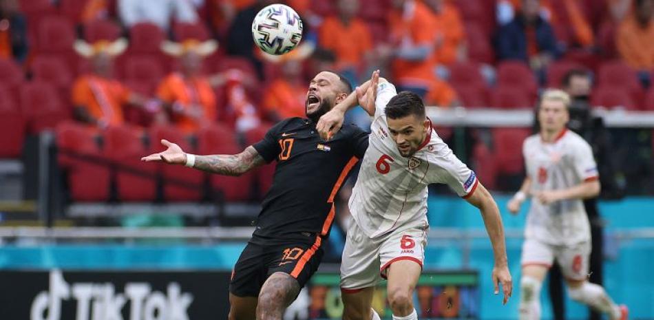 Memphis Depay, de Holanda, a la izquierda, lucha por un balón con Visar Musliu, de Macedonia del Norte, durante el partido del Grupo C de la Eurocopa.