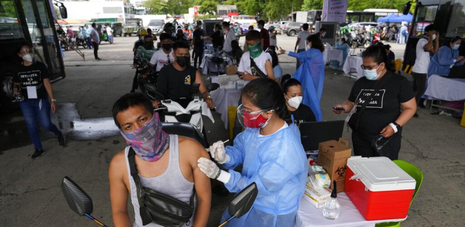Un conductor de motocicleta recibe una dosis de la vacuna contra el COVID-19 desarrollada por la farmacéutica china Sinovac en un puesto de vacunación en Manila, Filipinas, el 22 de junio de 2021.

Foto: AP/Aaron Favila
