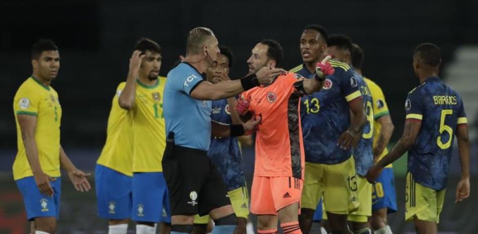 El arquero David Ospina, de Colombia, protesta ante el árbitro argentino Néstor Pitana durante un partido de la Copa América ante Brasil.