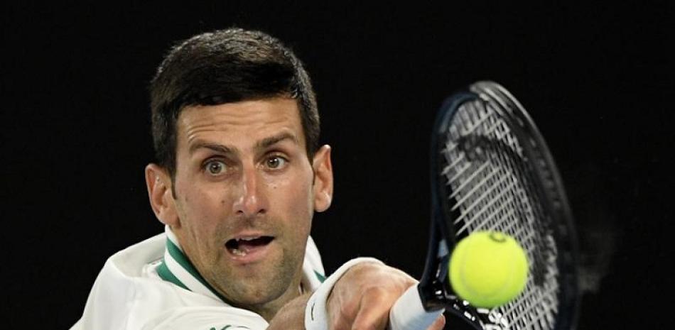 En imagen de archivo del domingo 21 de febrero de 2021, Novak Djokovic conecta un revés en un duelo con Daniil Medvedev en la final del Abierto de Australia.
