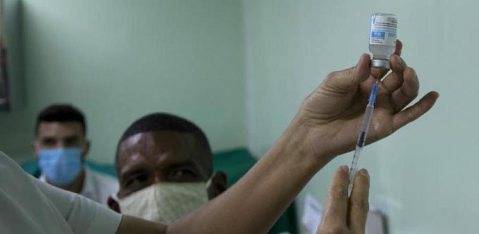 Eusebio Torres espera ser vacunado mientras una enfermera prepara la dosis de la vacuna cubana Abdala para el COVID-19 en el hospital Gustavo Aldereguia de Cienfuegos, Cuba, el domingo 30 de mayo de 2021. (AP Foto/Ismael Francisco)