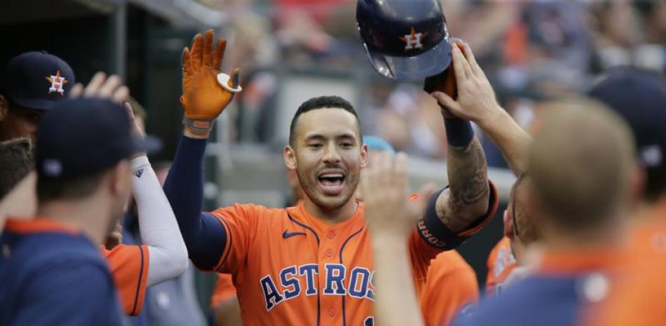 Carlos Correa de los Astros de Houston celebra en la caseta luego de pegar un jonrón solitario.