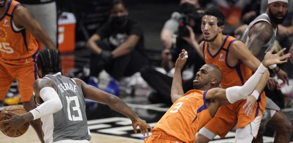 El jugador de los Clippers de Los Ángeles Paul George, a la izquierda, hace una falta al jugador de los Suns de Phoenix Chris Paul en la primera mitad del cuarto juego de las finales del oeste de la NBA, en Los Ángeles. (AP Foto/Mark J. Terrill)