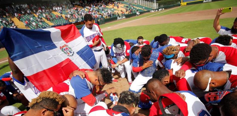 Los jugadores de República Dominicana oran luego de su victoria sobre Venezuela para clasificar a los Juegos Olímpicos.