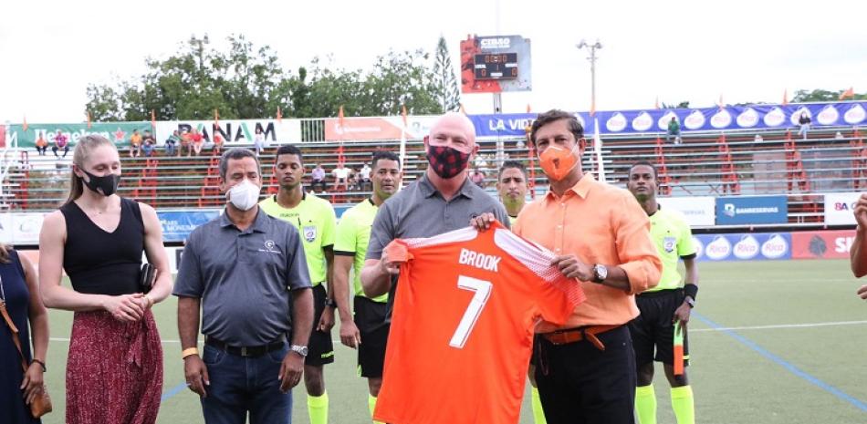 El presidente y fundador del ministerio Go Ministries, Brook Brotzman, recibe una camiseta de manos de Manuel Estrella, presidente del Cibao FC y de la LDF.