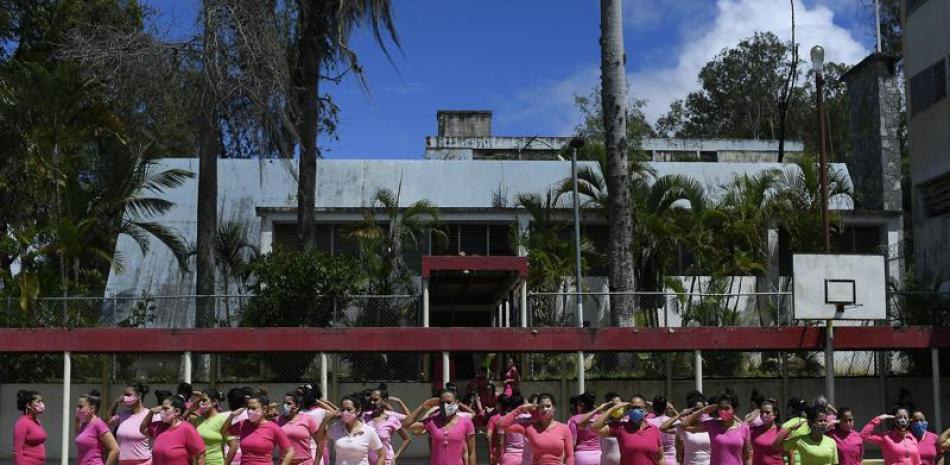 Un conjunto de reclusas saludan en formación antes de ser inoculadas con la vacuna de Sinopharm contra el COVID-19 el viernes 2 de julio de 2021, en la prisión para mujeres en Los Teques, estado Miranda, Venezuela. (AP Foto/Matías Delacroix)