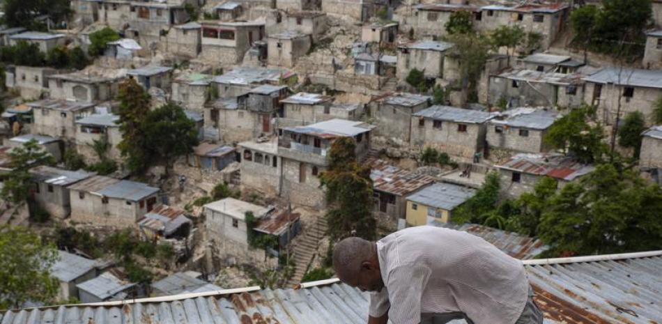 Antony Exilien trabaja para reforzar el techo de su vivienda en respuesta a la tormenta tropical Elsa, en Puerto Príncipe, Haití, el sábado 3 de julio de 2021. ( AP Foto/Joseph Odelyn)