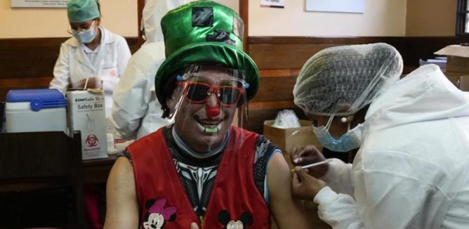 Un payaso recibe una inyección de la vacuna Sinopharm contra COVID-19 durante una campaña de vacunación dirigida a personas de entre 18 y 30 años. | AP