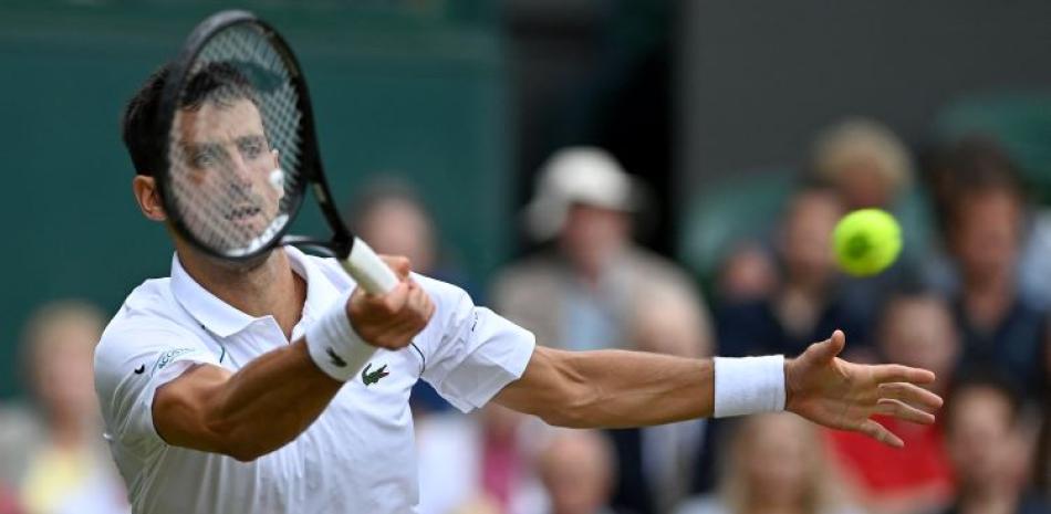 Novak Djokovic realiza una devolución en acción de su partido frente a Cristian Garín en los octavos de final del torneo de Wimbledon.