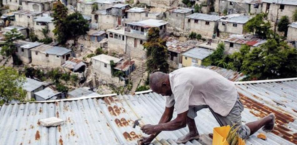 Antony Exilien trabaja para reforzar el techo de su vivienda en respuesta a la tormenta tropical Elsa, en Puerto Príncipe, Haití, el sábado. AP
