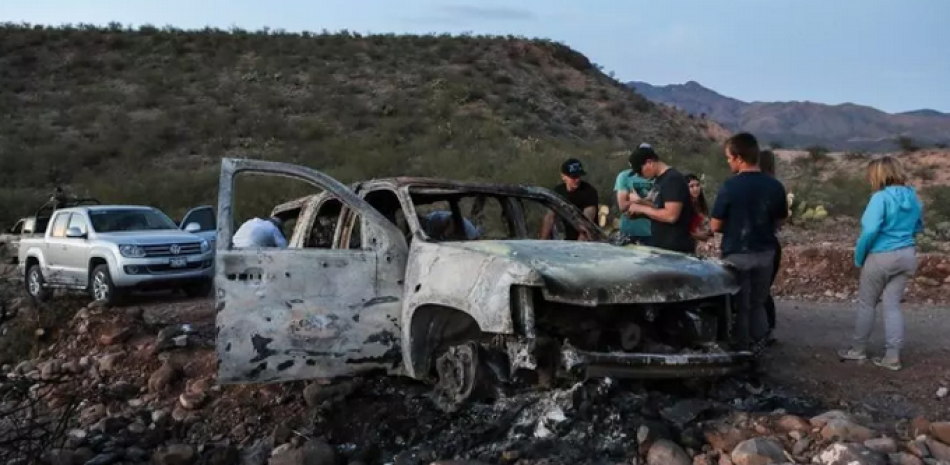 Miembros de la familia LeBarón miran un auto quemado en la que tuvo lugar parte de la masacre, este 5 de noviembre de 2019 en México. STR / AFP