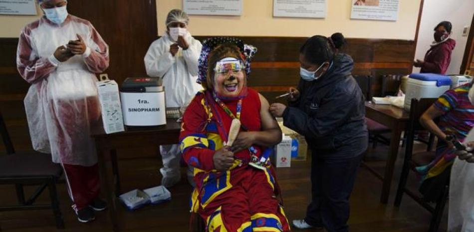 Un payaso recibe una inyección de la vacuna Sinopharm contra COVID-19 durante una campaña de vacunación dirigida a personas de entre 18 y 30 años en la Universidad pública San Andrés en La Paz, Bolivia, el lunes 5 de julio de 2021. (AP Foto/Juan Karita)