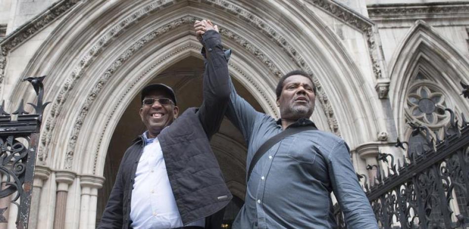 Paul Green, izquierda, y Cleveland Davidson festejan frente a la Corte Real de Justicia en Londres, martes 6 de julio de 2021. La corte de apelaciones absolvió a tres hombres negros condenados por robo hace casi 50 años. (Stefan Rousseau/PA via AP)