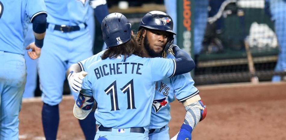 Vladimir Guerrero Jr., de los Azulejos, es felicitado por Bo Bichette luego de anotar una de las carreras del equipo en el partido del miércoles.