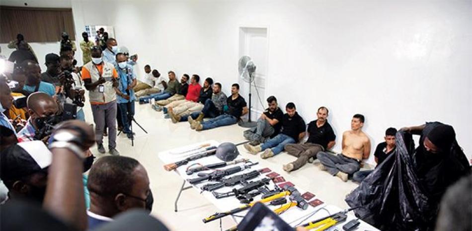 Extranjeros sospechosos del asesinato del presidente Jovenel Moïse, son mostrados a la prensa junto a armamentos usados en la acción. AP