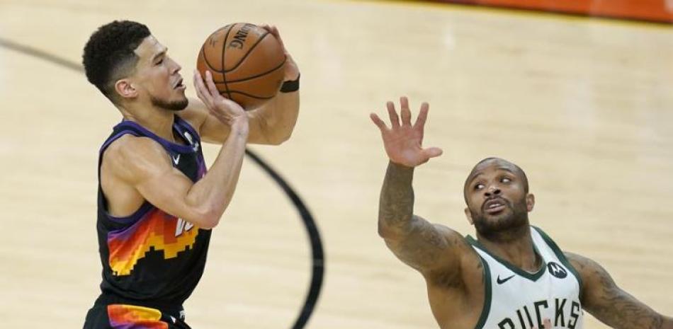 El escolta de Phoenix, Devin Booker, dispara ante la defensiva del alero de los Bucks, P.J. Tucker, en la segunda mitad del segundo juego de las Finales de la NBA.