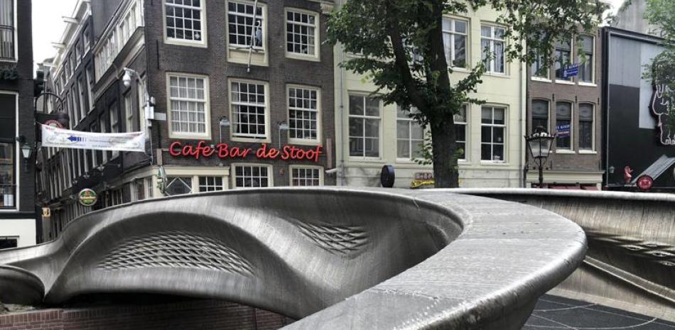 Un puente de acero impreso en 3D cruza un canal en Amsterdam, en esta foto del jueves, 15 de julio del 2021. Las líneas curvas del punte fueron creadas usando una técnica especial de impresión en 3D que combina robótica y soldadura. (AP Photo/Aleksandar Furtula)