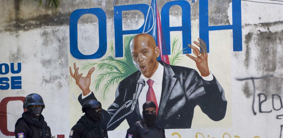 La policía se para cerca de un mural que muestra al presidente haitiano Jovenel Moise, cerca de la residencia del líder donde fue asesinado por hombres armados en las primeras horas de la mañana en Puerto Príncipe, Haití, el miércoles 7 de julio de 2021.

Foto: AP/Joseph Odelyn