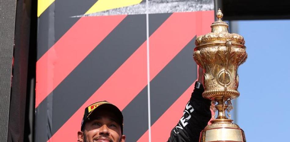 Lewis Hamilton levanta el trofeo que lo acreditado como ganador del Gran Premio de Gran Bretaña en el Mundial de Fórmula Uno.