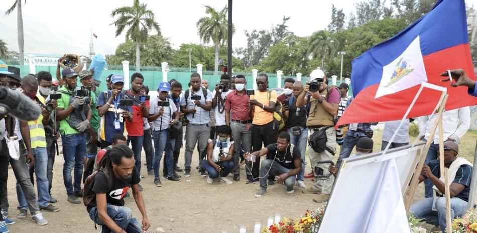 La gente presenta sus respetos fuera del Palacio Presidencial en Puerto Príncipe el 14 de julio de 2021, a raíz del asesinato del presidente haitiano Jovenel Moise que ocurrió temprano el 7 de julio de 2021.

Foto: Valerie Baeriswyl / AFP