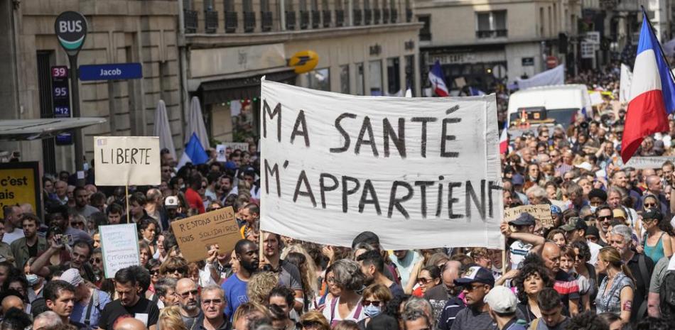 Manifestantes antivacunas desfilen en París para protestar contra las medidas más recientes del gobierno francés para combatir el incremento de infecciones con coronavirus. (AP Foto/Michel Euler)