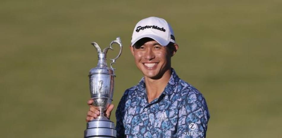 Collin Morikawa posa con el trofeo en el hoyo 18 hoyo después de ganar el Abierto Británico en el club de golf Royal St George's en Sandwich, Inglaterra.