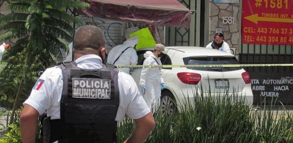 Elementos de la policía municipal y agentes periciales resguardan una escena del crimen del periodista Abraham Mendoza, en la ciudad de Morelia, estado de Michoacán.