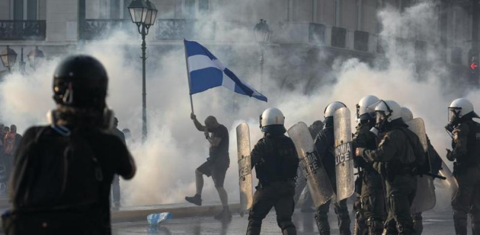 La policía de Grecia usa gas lacrimógeno para dispersar a unos manifestantes durante un mitin en la plaza Sintagma, en el centro de Atenas, el miércoles 21 de julio de 2021. (AP Foto/Yorgos Karahalis)